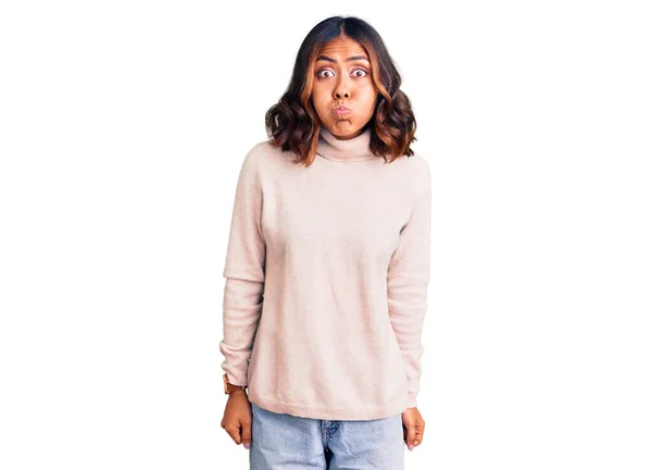 Young Beautiful Mixed Race Woman Wearing Winter Turtleneck Sweater Puffing — Stock Photo, Image