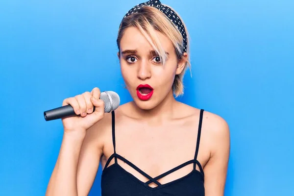 Jovem Bela Mulher Loira Cantando Música Usando Microfone Assustado Surpreso — Fotografia de Stock