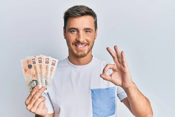 Handsome Caucasian Man Holding United Kingdom Pounds Banknotes Doing Sign —  Fotos de Stock