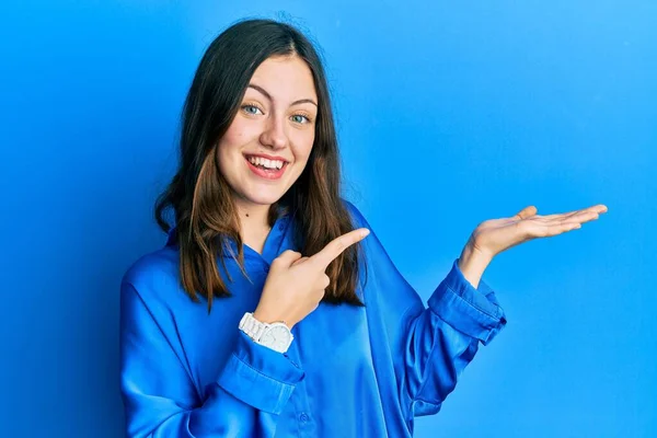 Młoda Brunetka Ubrana Luźną Niebieską Koszulę Zachwycona Uśmiechnięta Aparatu Prezentująca — Zdjęcie stockowe