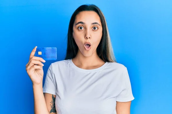 Młoda Latynoska Kobieta Trzymająca Kartę Kredytową Przestraszona Zdumiona Otwartymi Ustami — Zdjęcie stockowe