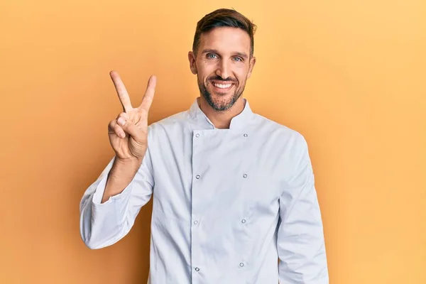 Handsome Man Beard Wearing Professional Cook Uniform Showing Pointing Fingers — Φωτογραφία Αρχείου