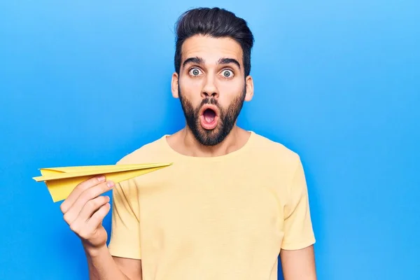 Joven Hombre Guapo Con Barba Sosteniendo Avión Papel Amarillo Asustado —  Fotos de Stock