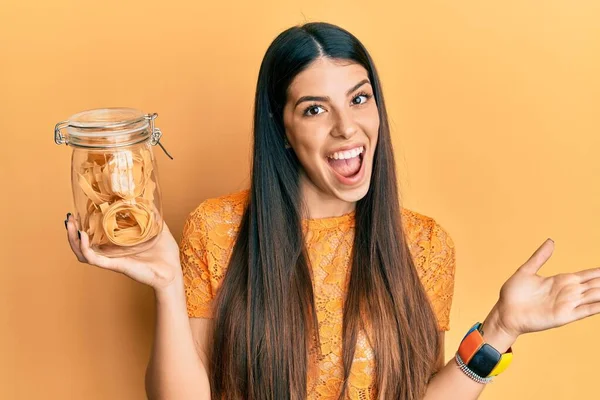 Young Hispanic Woman Holding Jar Uncooked Pasta Celebrating Achievement Happy — ストック写真