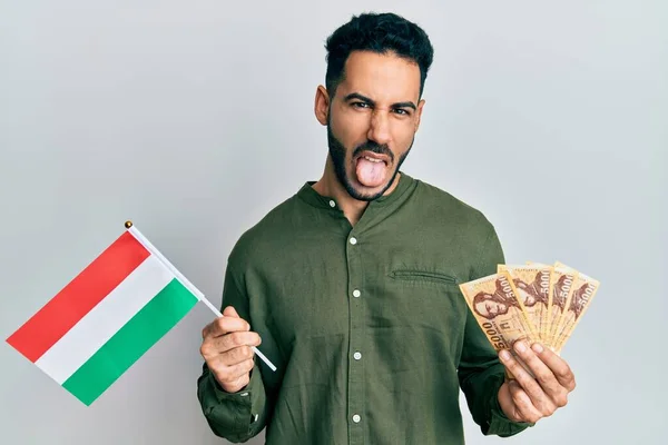 Mladý Hispánec Drží Maďarskou Vlajku Forints Trčí Jazyk Šťastný Legračním — Stock fotografie