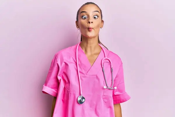 Mujer Hispana Joven Vistiendo Uniforme Médico Estetoscopio Haciendo Cara Pez —  Fotos de Stock