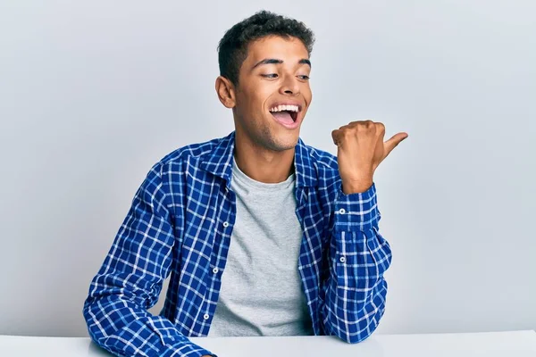 Genç Yakışıklı Afro Amerikalı Günlük Giysiler Içinde Masaya Oturmuş Gülümsüyor — Stok fotoğraf