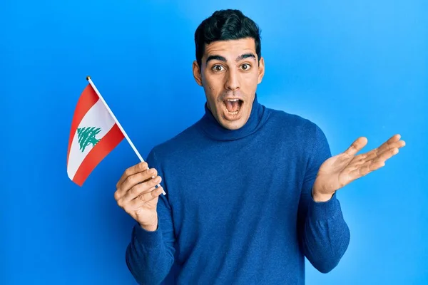 Pohledný Hispánec Držící Libanonskou Vlajku Oslavující Úspěch Šťastným Úsměvem Vítězným — Stock fotografie