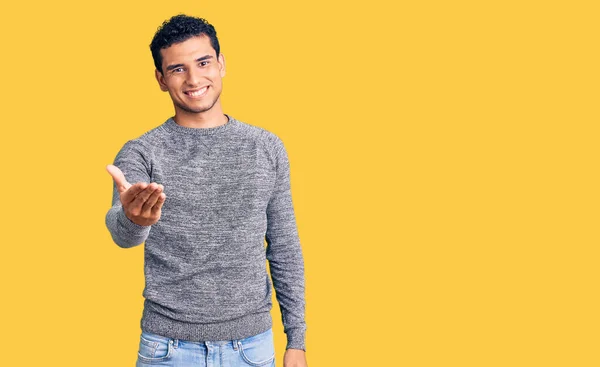 Joven Guapo Hispano Usando Suéter Casual Sonriente Amistoso Ofreciendo Apretón —  Fotos de Stock