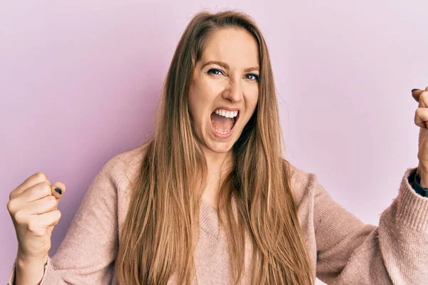 Young Blonde Woman Wearing Casual Sweater Screaming Proud Celebrating Victory — Fotografia de Stock