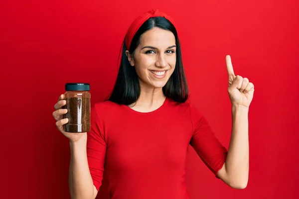 Mujer Hispana Joven Sosteniendo Café Soluble Sonriendo Con Una Idea —  Fotos de Stock