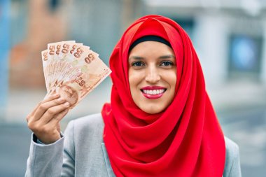 Şehre tesettürlü genç bir Arap kadın Türk lira banknotları taşıyor..