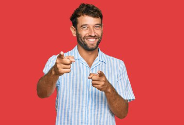 Sakallı, sıradan, temiz tişörtlü, neşeli ve komik yüzlü genç bir adam. iyi enerji ve titreşimler. 