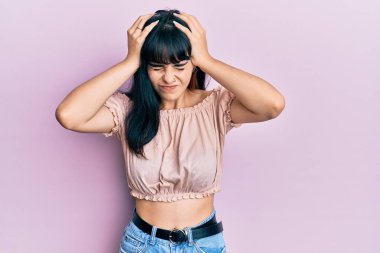 Genç İspanyol kız gündelik kıyafetler giyiyor. Baş ağrısı çekiyor. Acı ve migren yüzünden çaresiz ve stresli. Eller başının üstünde.. 