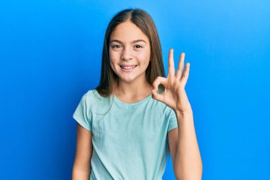 Güzel, esmer, beyaz tişört giyen, gülümseyen, el ve parmaklarıyla 