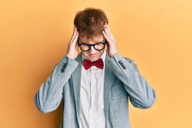 Genç, beyaz tenli, gözlüklü, hippi görünümlü, papyonlu, baş ağrısı çeken, çaresiz ve stresli bir adam. Çünkü acı ve migren. Eller başının üstünde.. 