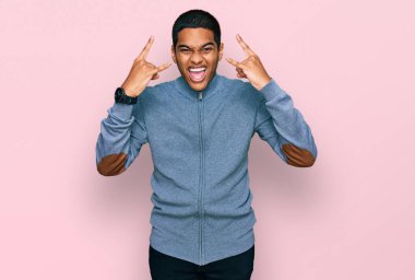 Genç, yakışıklı, İspanyol kazak giyen, çılgın bir ifadeyle bağıran, elleri havada rock sembolü yapan bir adam. Müzik yıldızı. ağır müzik konsepti. 