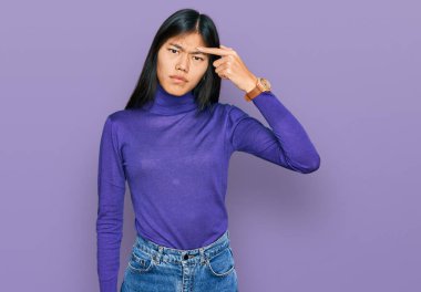 Sıradan kıyafetler giyen genç Asyalı güzel bir kadın alnındaki sivilceden mutsuz olduğunu gösteriyor. Siyah noktalı çirkin bir enfeksiyon. sivilce ve deri problemi 