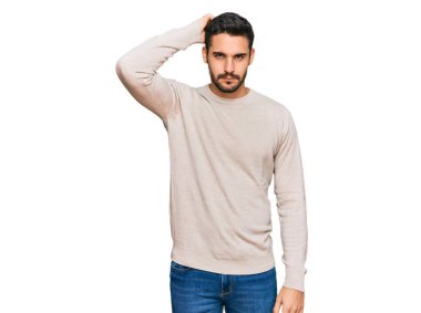 Gündelik kıyafetler giyen genç İspanyol adam soru sorup kafasını karıştırıyor. Şüpheyle kararsız, kafa kafaya düşünerek. Düşünceli kavram. 