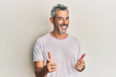 Orta yaşlı, gri saçlı, sıradan kıyafetler giyen mutlu ve komik yüzlü bir adam. iyi enerji ve titreşimler. 