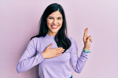 Latin kökenli genç bir kadın gündelik kıyafetler giyip gülümsüyor. Göğsü ve parmakları havada küfür ediyor. Sadakat yemini ediyor. 