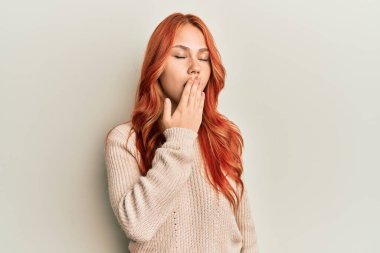 Genç, güzel, kızıl saçlı, sıradan bir kazak giyen bir kadın. Ağzı eliyle kapatmaktan sıkılmış. Huzursuz ve uykulu.. 