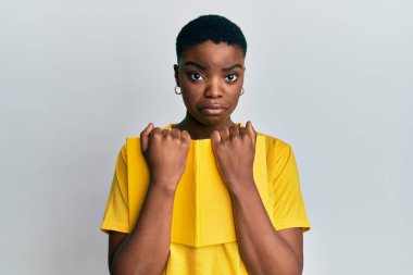 Genç Afro-Amerikalı kadın elinde kitap tutarken üzgün ve endişeli, sinirli ve korkmuş bir şekilde ağlıyor. hüzünlü ifade. 