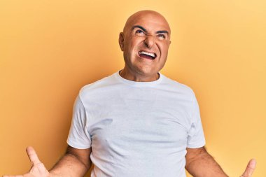 Olgun bir Orta Doğulu adam, sıradan beyaz tişörtler giyip deli gibi bağırıyor ve agresif bir ifade ve kollarla bağırıyor. hüsran kavramı. 