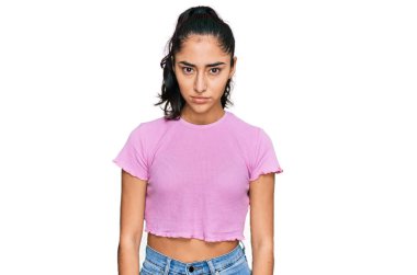 Diş teli takan, sıradan kıyafetler giyen, kuşkucu ve gergin bir İspanyol genç kız, sorun yüzünden surat asıyor. negatif kişi. 