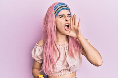 Pembe saçlı, elleri ağızda bağıran ve yüksek sesle bağıran İspanyol bir kız. iletişim konsepti. 
