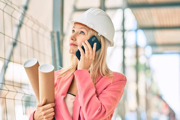 若い白人建築家の女性は 市内のスマートフォンで真剣な表情で話しています — ストック写真