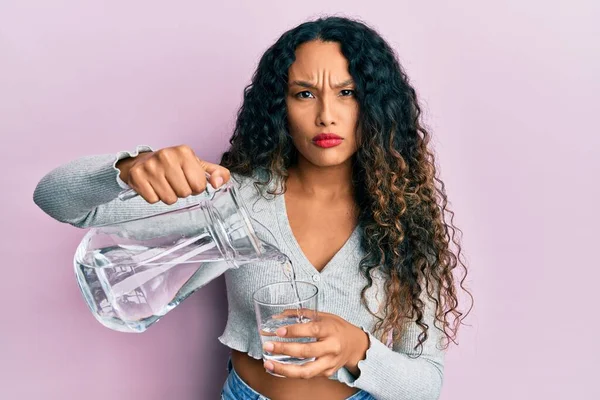 Ung Latinamerikansk Kvinna Häller Vatten Skeptisk Och Nervös Rynkar Pannan — Stockfoto