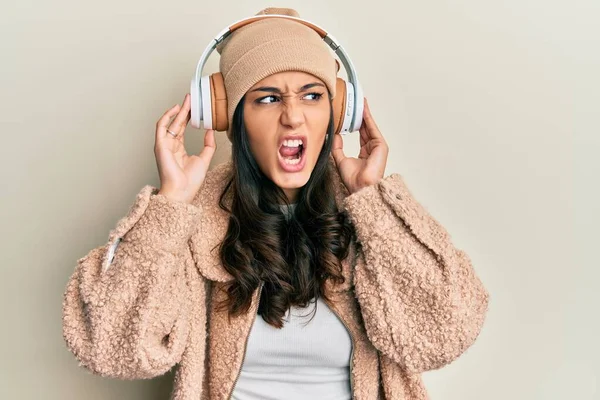 Mujer Hispana Joven Escuchando Música Usando Auriculares Enojados Locos Gritando —  Fotos de Stock