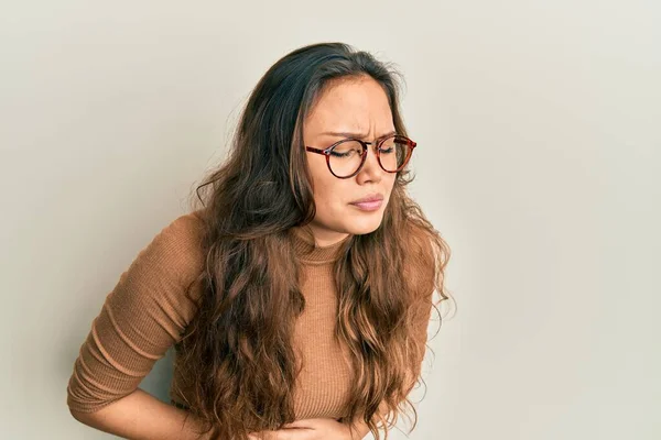 若いヒスパニック系の女の子の胃の上に手でカジュアルな服や眼鏡を着用するため 消化不良 痛みを伴う病気の気分が悪い キャッシュ コンセプト — ストック写真