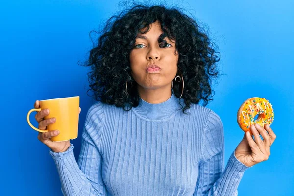 Jovem Hispânica Comendo Donut Bebendo Café Soprando Bochechas Com Rosto — Fotografia de Stock