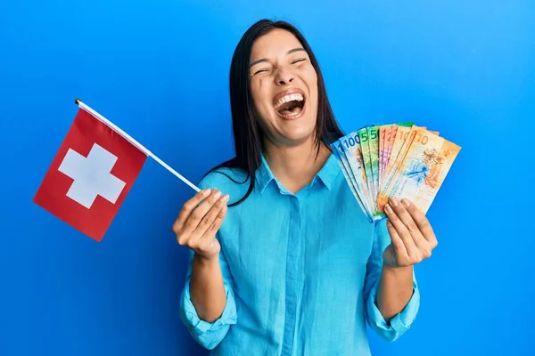 Young Latin Woman Holding Switzerland Flag Franc Banknotes Celebrating Crazy — Stock fotografie