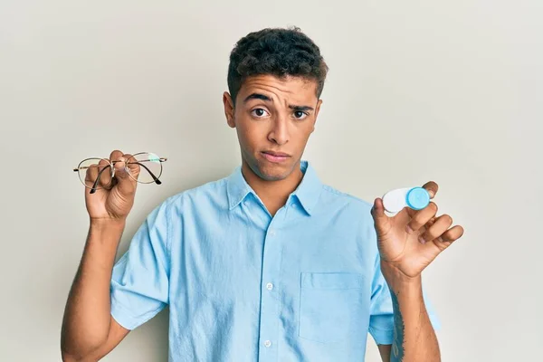 Young Handsome African American Man Holding Glasses Contact Lenses Skeptic — Stock Photo, Image