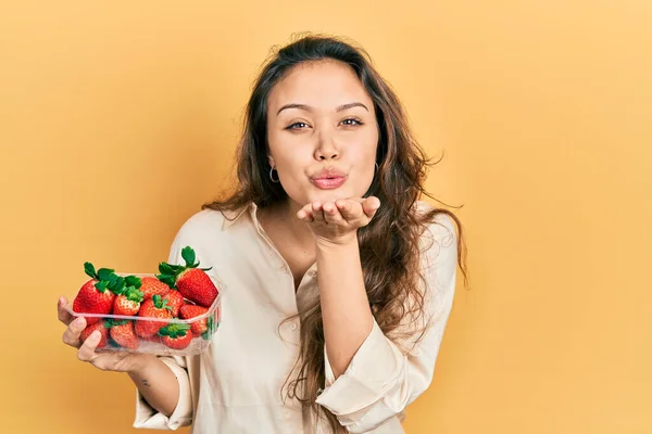 Young Hispanic Girl Holding Strawberries Looking Camera Blowing Kiss Hand — Φωτογραφία Αρχείου