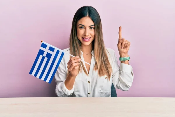 Jovem Hispânica Segurando Bandeira Grécia Sentada Mesa Sorrindo Com Uma — Fotografia de Stock