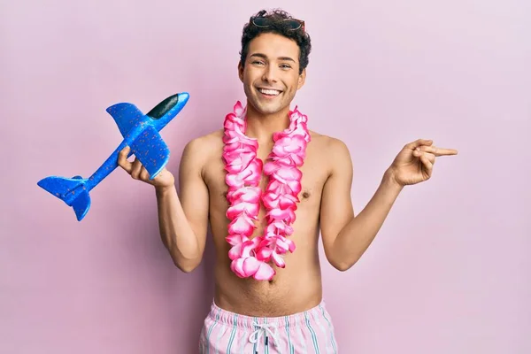 Young Handsome Man Wearing Swimsuit Hawaiian Lei Holding Airplane Toy — Stock fotografie