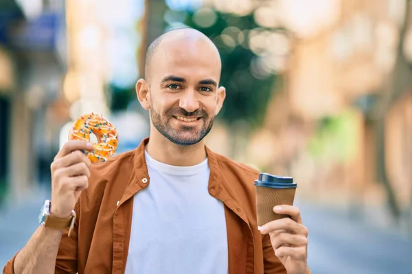 Young hispanic bald man smiling happy having breakfast at the city.