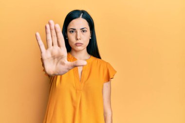 Günlük kıyafetler giyen güzel genç bir kadın avucunun içi gibi şarkı söylemeyi kesiyor. Yüzünde olumsuz ve ciddi bir jest olan uyarı ifadesi. 