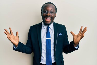 Yakışıklı, takım elbiseli ve kravatlı genç bir adam zaferi mutlu bir gülümsemeyle kutluyor ve elleri havada kazanan bir ifade takınıyor. 