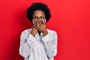 Sıradan kıyafetler ve gözlük takan Afro-Amerikalı genç bir kadın yanlışlıkla ağızlarını kapatarak şok geçirdi. gizli kavram. 