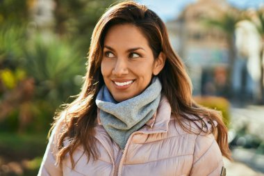 Genç İspanyol kadın gülümseyerek şehirde mutlu mesut dikiliyor..