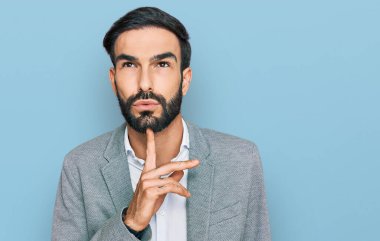 İş kıyafetleri giyen genç İspanyol adam şüpheye odaklanmıştı. Parmakları çenesinde ve yukarı bakıyordu. 