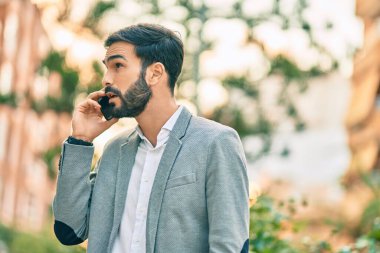 Genç İspanyol iş adamı ciddi bir ifadeyle şehirdeki akıllı telefondan konuşuyor..