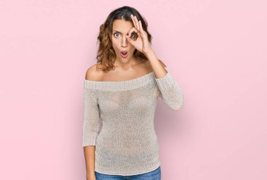 Güzel, genç, beyaz bir kadın günlük kıyafetler giyiyor. Şaşırmış yüz ifadesiyle şaşırmış, parmaklarından bakan gözler. İnançsız ifade. 