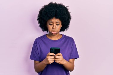 Genç Afro-Amerikalı kadın akıllı telefon kullanıyor. Depresyonda ve endişe içinde, sinirli ve korkmuş bir şekilde mesaj yazıyor. hüzünlü ifade. 