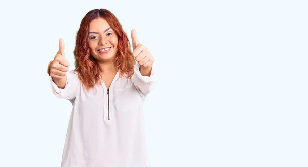 年轻的拉丁女人穿着休闲装 赞成用手做一个积极的手势 微笑着竖起大拇指 为成功感到高兴 优胜手势 — 图库照片